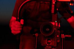 Nighttime Capture. Professional Videographer Films Athletes Running in Red-Lit Darkness photo