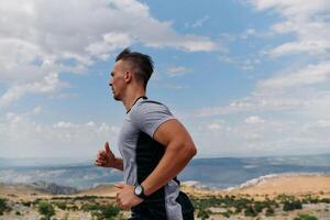 Determined Athlete Running Through Rugged Mountain Terrain at Sunrise. photo