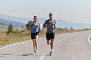 energizado por el belleza de naturaleza, un Pareja potestades mediante su Mañana correr, su cuerpos y espíritu revitalizado. foto