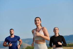 A group of friends maintains a healthy lifestyle by running outdoors on a sunny day, bonding over fitness and enjoying the energizing effects of exercise and nature photo