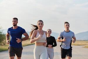 un grupo de amigos mantiene un sano estilo de vida por corriendo al aire libre en un soleado día, unión terminado aptitud y disfrutando el energizante efectos de ejercicio y naturaleza foto