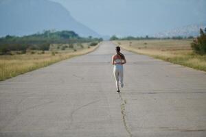 A determined woman athlete trains for success in the morning sun. photo