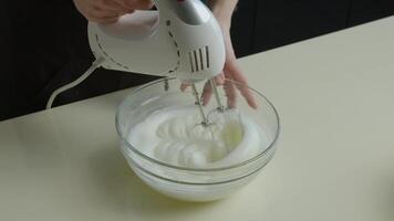 A mixer beats the egg whites in a clear bowl video