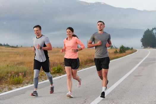 A group of friends, athletes, and joggers embrace the early morning hours as they run through the misty dawn, energized by the rising sun and surrounded by the tranquil beauty of nature photo