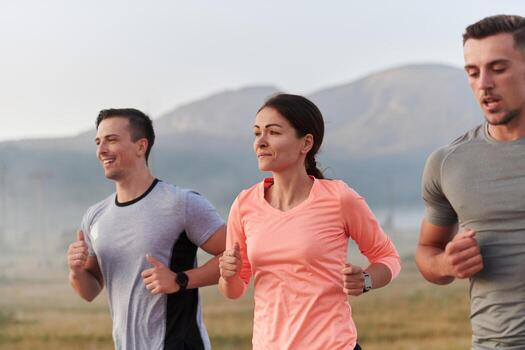 A group of friends, athletes, and joggers embrace the early morning hours as they run through the misty dawn, energized by the rising sun and surrounded by the tranquil beauty of nature photo