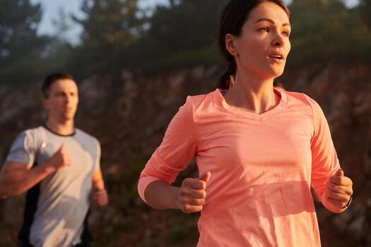 A group of friends, athletes, and joggers embrace the early morning hours as they run through the misty dawn, energized by the rising sun and surrounded by the tranquil beauty of nature photo