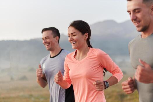 A group of friends, athletes, and joggers embrace the early morning hours as they run through the misty dawn, energized by the rising sun and surrounded by the tranquil beauty of nature photo