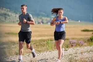 energizado por el belleza de naturaleza, un Pareja potestades mediante su Mañana correr, su cuerpos y espíritu revitalizado. foto