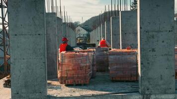 construtores trabalhando em construção e deitado tijolos. alvenaria do uma tijolo de vários andares construção video