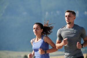 energizado por el belleza de naturaleza, un Pareja potestades mediante su Mañana correr, su cuerpos y espíritu revitalizado. foto