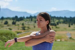 determinado estirar. atlético mujer abraza post-ejecución flexibilidad en naturaleza. foto