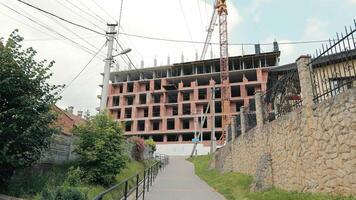 An unfinished multi-story brick building that is under construction. Bottom view of the house under construction video