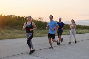 A diverse group of runners trains together at sunset. photo