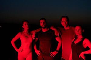 Diverse Athletes Unwind. Post-Marathon Rest Under Red Nighttime Glow. photo