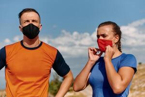 Couple running in nature at morning wearing protective face masks photo