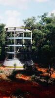 A futuristic glass greenhouse in the midst of a lush forest video