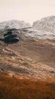 slow motion Vietnam War era helicopter in mountains video