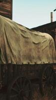 An antique covered wagon in front of a historical building video