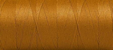 Texture of threads in a spool of brown color on a white background photo