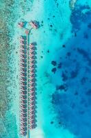 Maldives paradise water villas. Tropical aerial landscape, seascape with long jetty, water villas with amazing sea and lagoon ocean beach, tropical nature. Exotic tourism destination, summer vacation photo