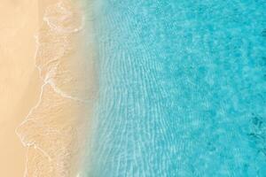 Summer seascape beautiful waves, blue sea water in sunny day. Top view from drone. Sea aerial view, amazing tropical nature background. Beautiful bright sea waves splashing and beach sand sunset light photo