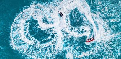 People are playing a jet ski in the sea. Aerial top view, amazing nature background. tropical beach. Outdoor sport and recreation activity, amazing aerial. Freedom adventure beach day photo