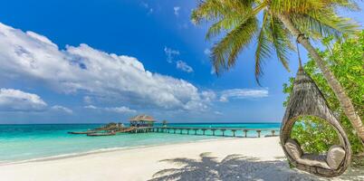 Tropical beach panorama summer relax landscape with beach swing or hammock hang on palm tree over white sand sea beachside tourism. Amazing beach vacation summer holiday coast. Luxury romantic travel photo