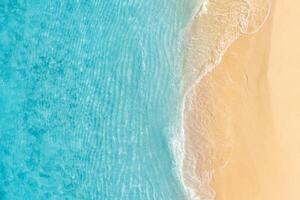 Summer seascape beautiful waves, blue sea water in sunny day. Top view from drone. Sea aerial view, amazing tropical nature background. Beautiful bright sea with waves splashing and beach sand concept photo