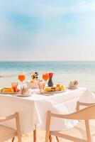 Fresh breakfast in a beautiful location with sea views. Luxury summer vacation or honeymoon destination. Table with gourmet delicious food near the sea with horizon. Beautiful summer breakfast setting photo