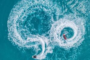 Aerial view of water extreme action sport, summer sea, close to luxury tropical resort . Fly board in ocean lagoon, freedom fun as summer recreational activity. Flyboard view from drone photo