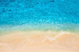 Summer seascape beautiful waves, blue sea water in sunny day. Top view from drone. Sea aerial view, amazing tropical nature background. Beautiful bright sea with waves splashing and beach sand concept photo