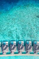 Maldives paradise water villas. Tropical aerial landscape, seascape with long jetty, water villas with amazing sea and lagoon ocean beach, tropical nature. Exotic tourism destination, summer vacation photo