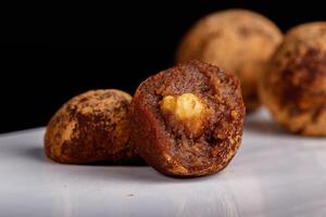 Beautiful candy truffle with a nut inside on a white plate on a black background photo