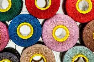 set of multi-colored spools of thread for sewing photo