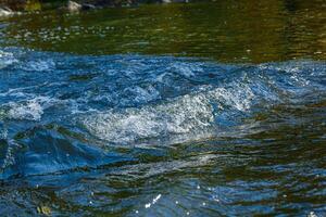 fluir de agua y rociar desde un Roca foto