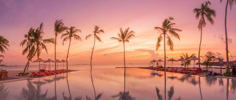 Outdoor luxury sunset over infinity pool swimming summer beachfront hotel resort, tropical landscape. Beautiful tranquil beach holiday vacation background. Amazing island sunset beach view, palm trees photo