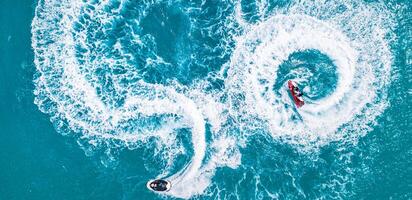 People are playing a jet ski in the sea. Aerial top view, amazing nature background. tropical beach. Outdoor sport and recreation activity, amazing aerial. Freedom adventure beach day photo