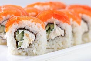 Sushi with salmon on a white plate with wasabi, ginger, soy, chopsticks on a white background photo
