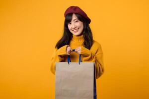 A happy young woman in a red beret and yellow sweater enjoys her shopping spree, holding a paper bag against a vibrant yellow background. photo