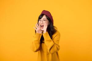 chic woman, wearing a red beret and yellow sweater, raises her voice against a vibrant yellow background. photo