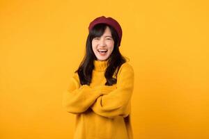 With infectious laughter, a young Asian woman in a yellow sweater and red beret brightens the scene against a sunny yellow background. photo