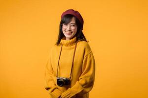 A creative artist, this young Asian woman, dressed in a yellow sweater and red beret, captures moments with her camera, a delightful hobby. photo