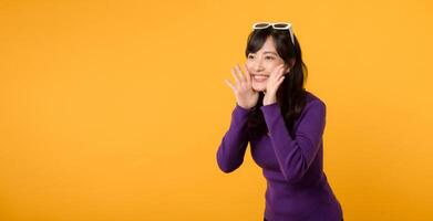 Excitement abounds as a fashionable lady, in a purple shirt and sunglasses against a yellow background, delivers a lively and positive message with vibrant gestures and a happy expression. photo