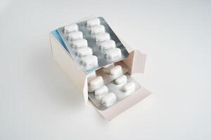 Open pack of pills on a white background. photo