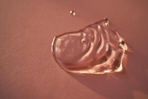 Beautiful volumetric drop of cosmetic product on a pink background. photo