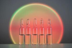 Ampoules for injection against the background of a bright orange circle. photo