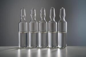 Five ampoules for injection with medicines on a grey background. photo
