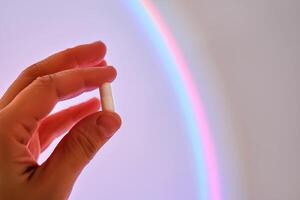 Capsule in hand against the background of a glowing circle. photo