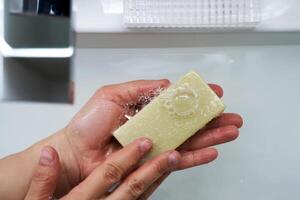 The process of washing hands with natural soap over the sink. photo