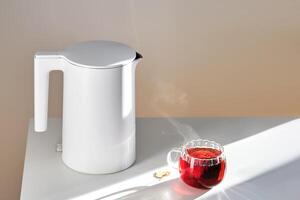 Glass mug with hot black tea on the table. photo